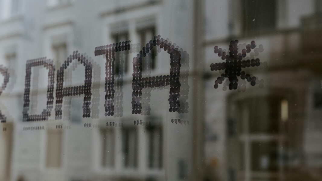 Window reflecting a building with the word Data on the window